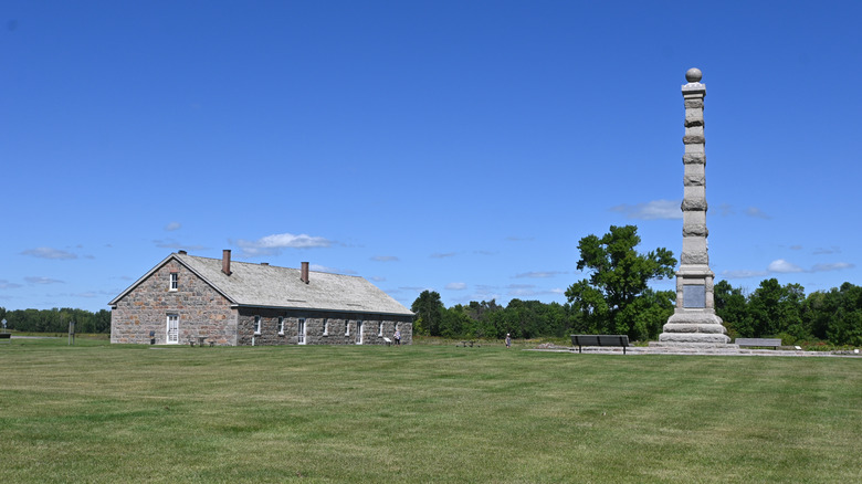 A stone monument and barracks rise out of the lawns of Fort Ridgely State Park, Minnesota
