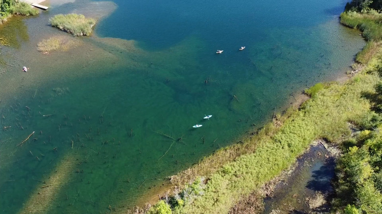 Kayakers paddling on crystal-clear water in the Cuyuna Mine Lakes in Minnesota