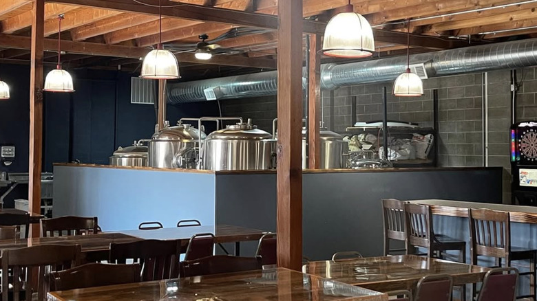 Interior of Lost Saint Brewing Company with tables and brewing equipment