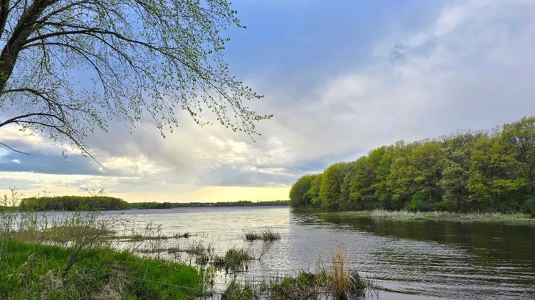 A suble sunset over a scenic waterway surrounded by greenery at Carlos Avery State WMA in Minnesota
