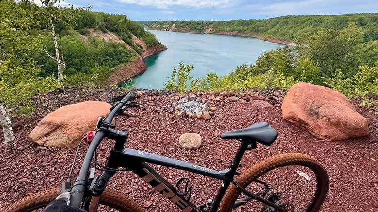 A bike parked on a trail overlooking a lake at Redhead Mountain Bike Park
