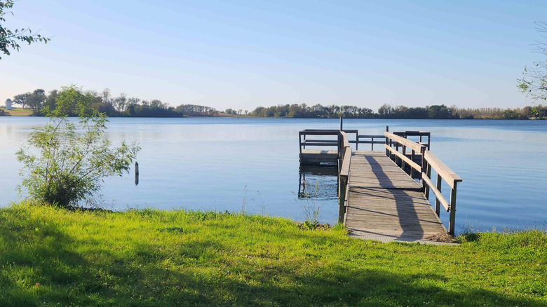 Grassy shoreline and wooden fishing pier at Monson Lake State Park, Minnesota