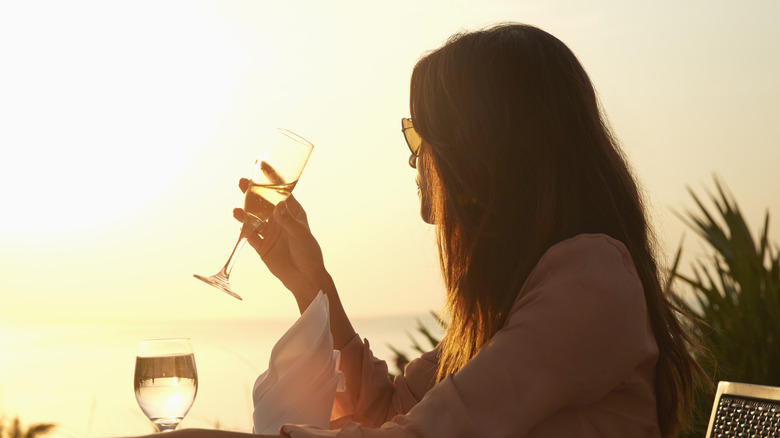 Woman enjoying champagne at sunset