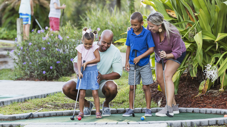 Family playing mini golf