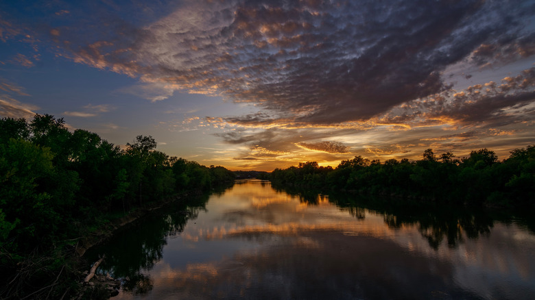 Sunset and surrounding trees reflecting on the Meramec River in Arnold, Missouri