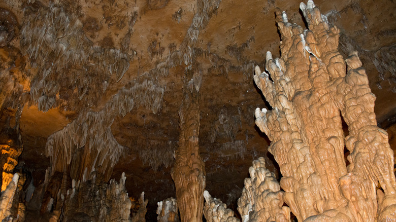 A cavern room inside a cave illuminated with formations hanging from the ceiling