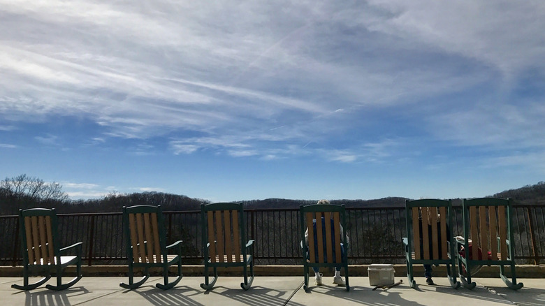 A row of Adirondack chairs overlooking the mountains and trees at Don Robinson State Park