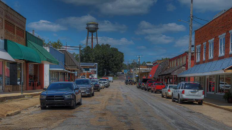 A street with colorful storefronts and cars parked on the side in Mountain View, Missouri