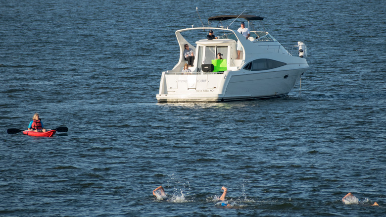 Boat, canoe, and swimmers in Smithville Lake