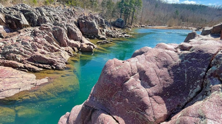 turquoise river flows between pink rocks