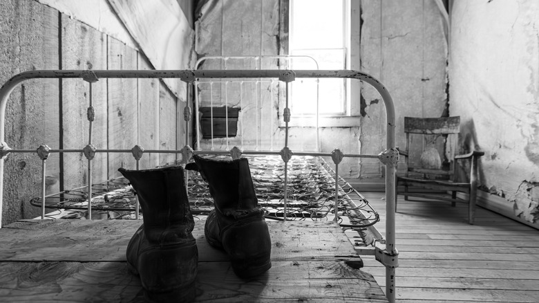 Interior image of a bedroom in one of the still-intact homes at Garnet Ghost Town, an abandoned mining town near Missoula, Montana, U.S.A., photographed in black and white on a bright day