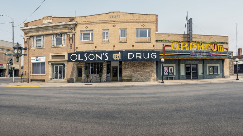 Historic storefronts in downtown Conrad, Montana, including a drug store and theater.