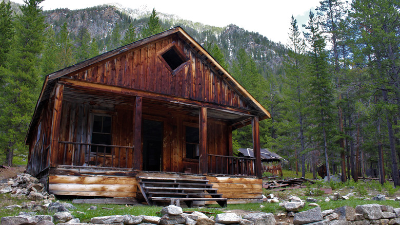 Abandoned wooden cabin in front of mountains Coolidge Montana