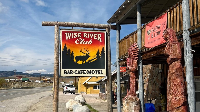 Wise River Club sign with blue sky and street