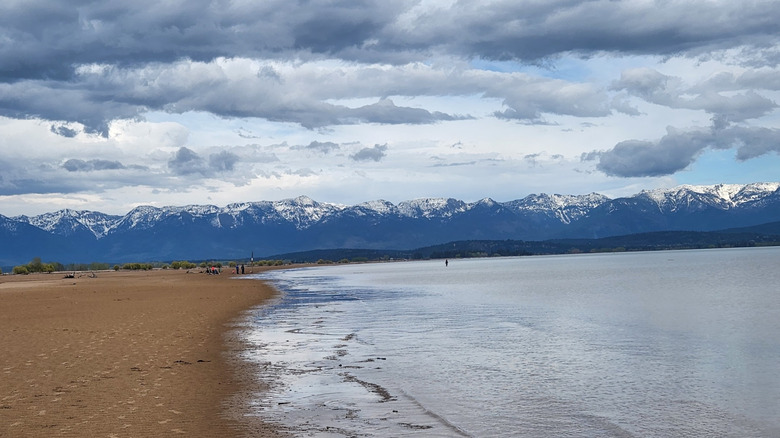 Somers Beach State Park's sandy shoreline, with the Swan Mountains in the distance