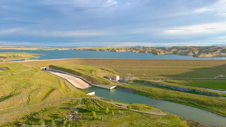 Tiber Dam surrounded by green grass and a big sky