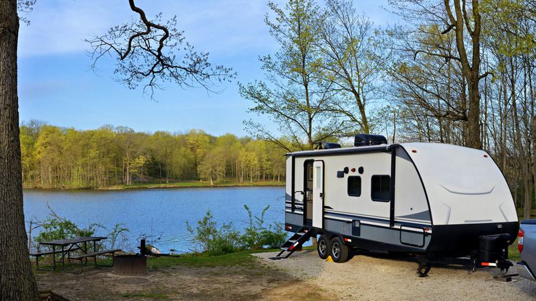 Travel trailer camping in the forest by the lake at Moraine View State Park, Illinois