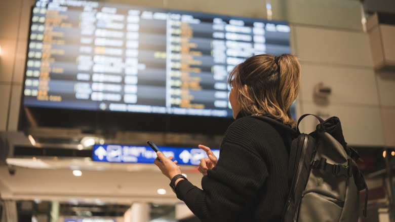Person looking at flight schedule in airport