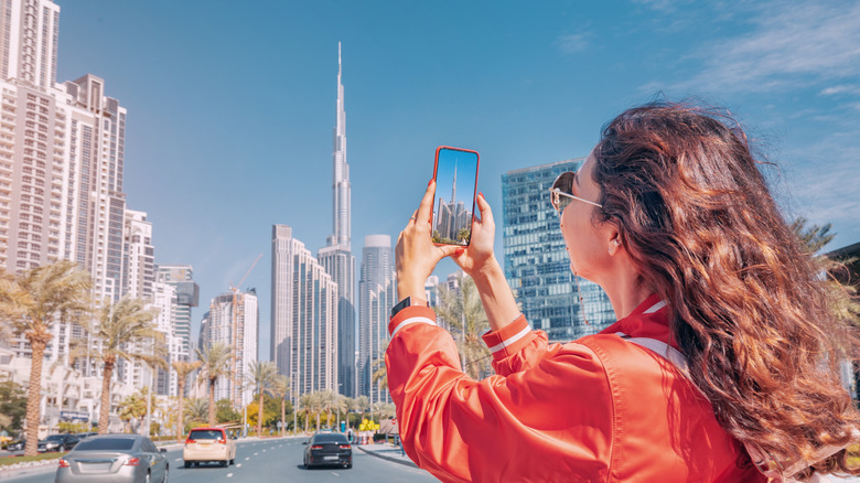 A female traveler takes a photo of the Burj Kalifa