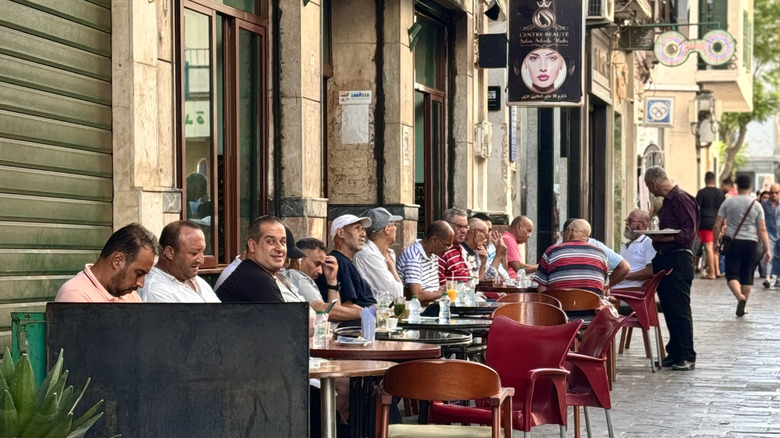 A group of Moroccan men sitting outside a café enjoying the street vibes while drinking coffee and chatting