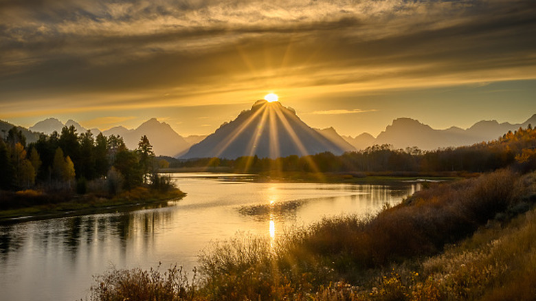 The sun setting behind the mountains at Oxbow Bend Overlook in Grand Teton National Park