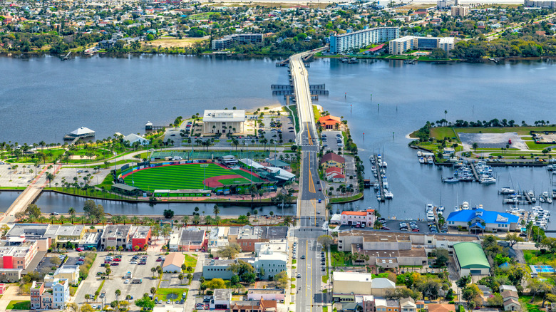 Aerial view of historic Jackie Robinson Ballpark with view of Daytona Beach buildings, roadways, and water, with ballpark prominently on the left