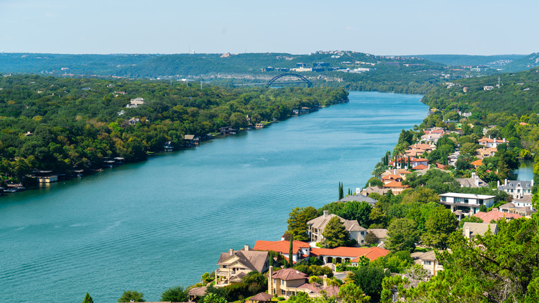 The view of the river with houses and trees alongside it from the cliffside of Mount Bonnell in Austin, Texas