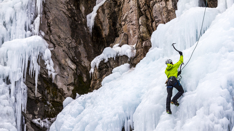 Climber scaling frozen ice wall