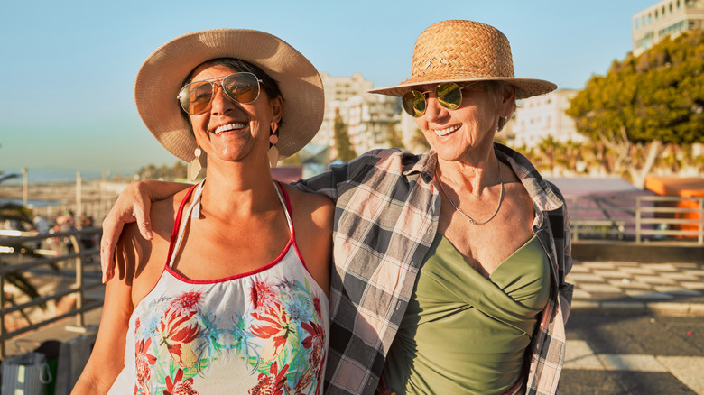 Two older women smiling in hats