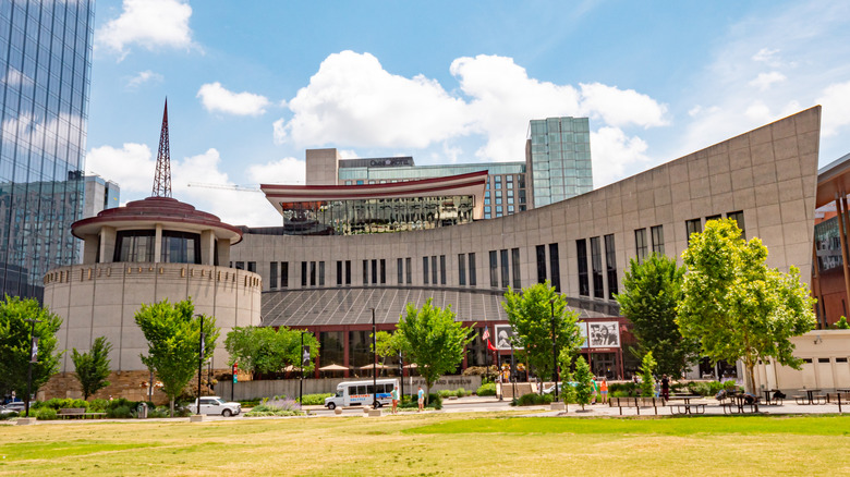 grass lawn in front of a rotunda and long pointed building, sky and clouds