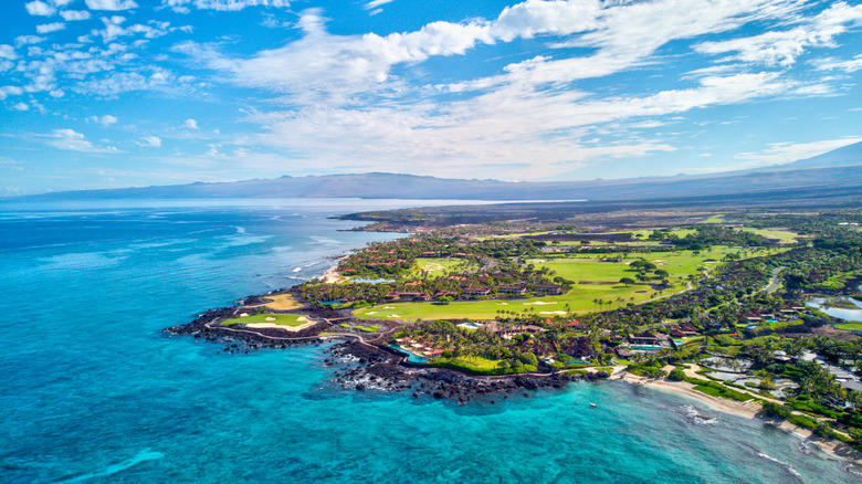 Aerial view of turquoise waters and verdant green golf course along the Big Island's Kohala Coast