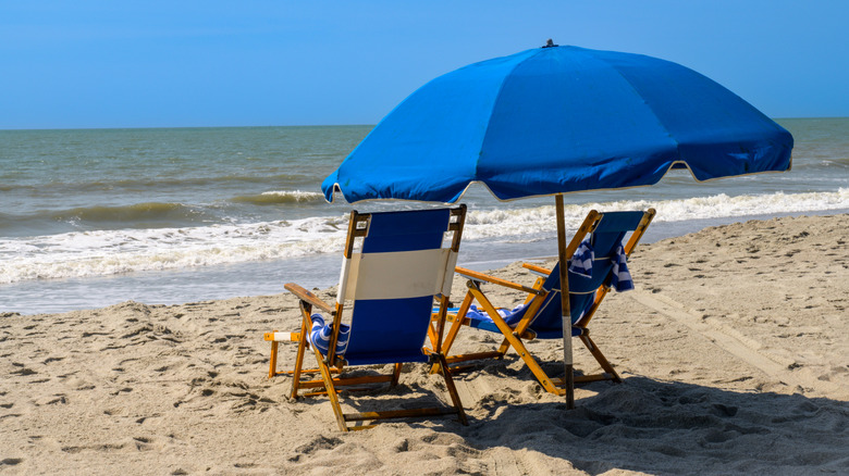 Beach chairs under a blue umbrella on the Atlantic Ocean