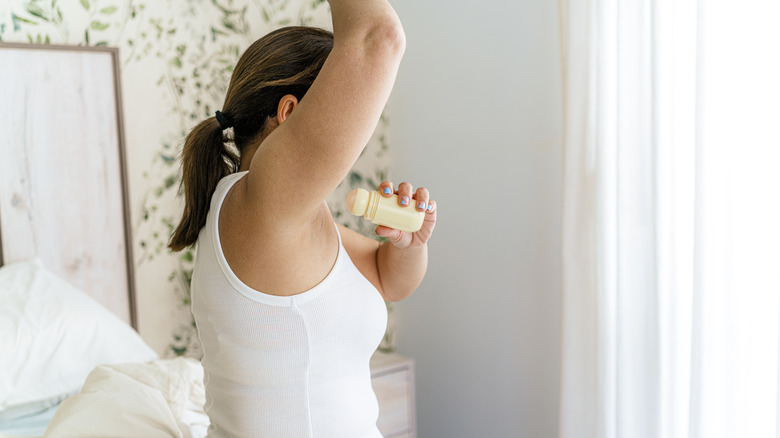 Woman applying deodorant
