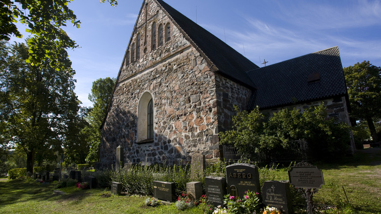 Stone church with steeple behind graveyard in Nagu archipelago, Finland