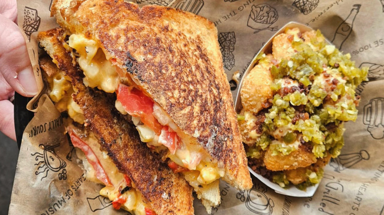 Grilled cheese sandwich and colorful side from Grilled Cheeserie rest on paper