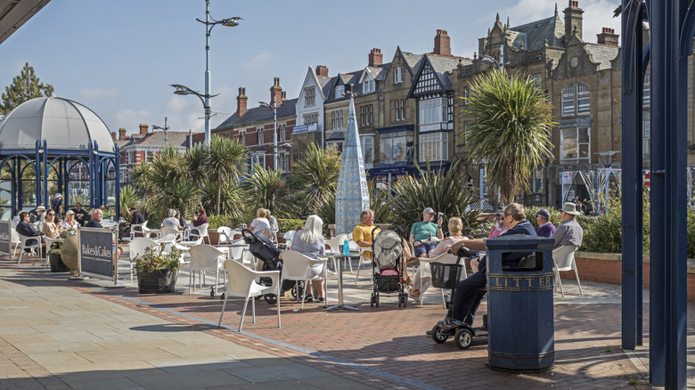 People sitting at tables on the promenade in Lytham St Annes, United Kingdom