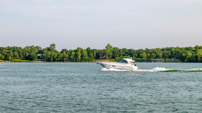 A small white boat speeds across the blue water at Table Rock Lake in Missouri