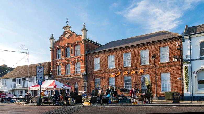 The facade of the Shepherd Neame Brewery and market stalls, Faversham, Kent, UK