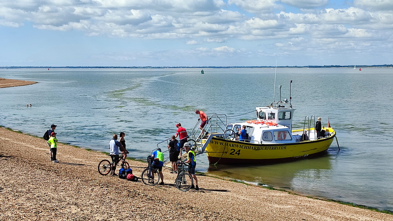 People getting off the Harbour Ferry in Felixstowe via a ladder directly onto the beach