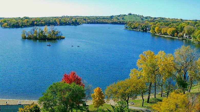 An aerial view of Crystal Lake with the beach park in the foreground, kayakers in the middle, and trees lining the shore