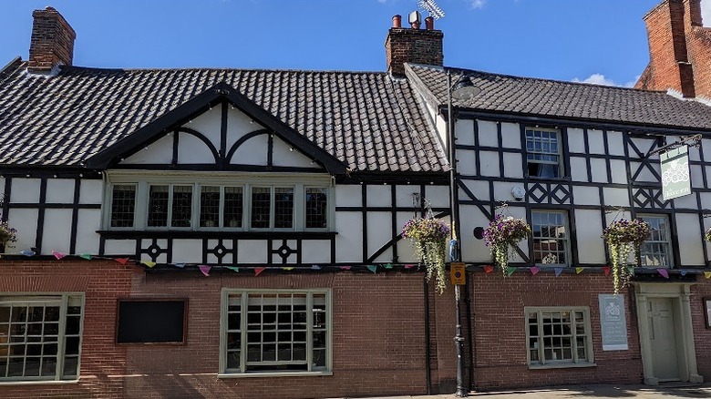 Street view of the historic building with exposed timber and brick walls housing The Fleece Inn in Bungay