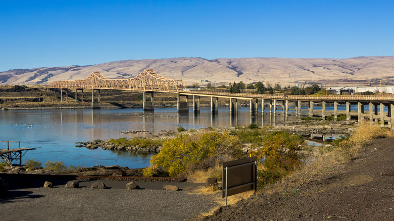 A view of the Dallas Bridge in Oregon with a mountain range in the background.