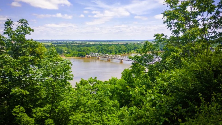 Riverview Park in Hannibal Missouri, featuring a bridge crossing the Mississippi River, framed by lush greenery