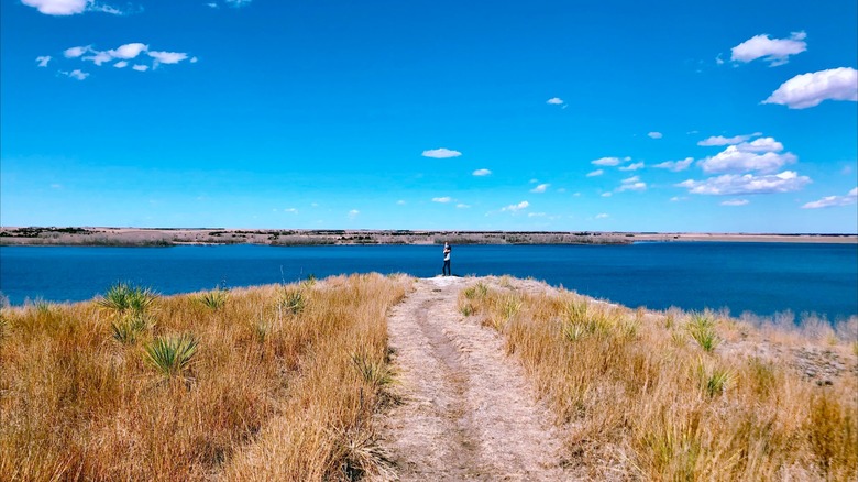 A person holding a baby by the reservoir at Prairie Dog State Park, Kansas