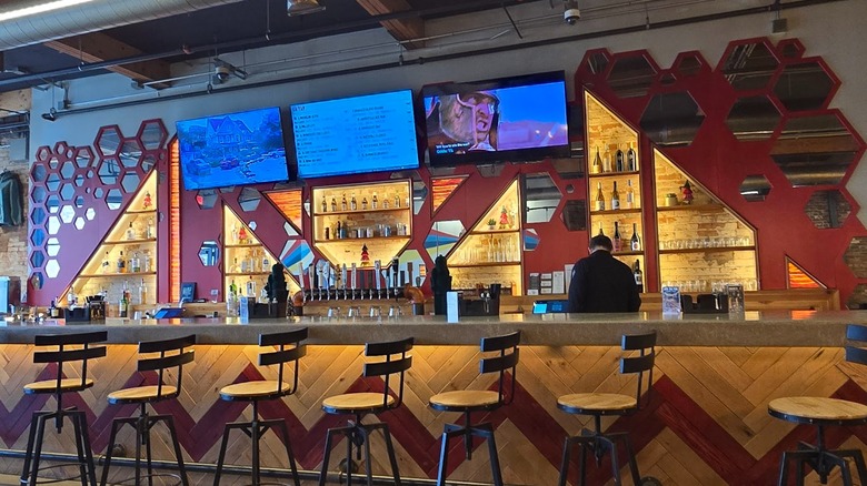 Colorful wooden and red bar with bartender at Oddfellows Ohio