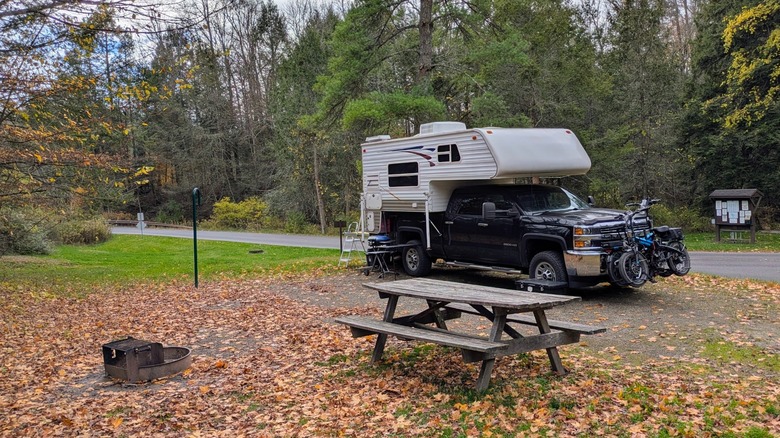 A vehicle parked at the campsite equipped with a picnic table at Hills Creek State Park, Pennsylvania