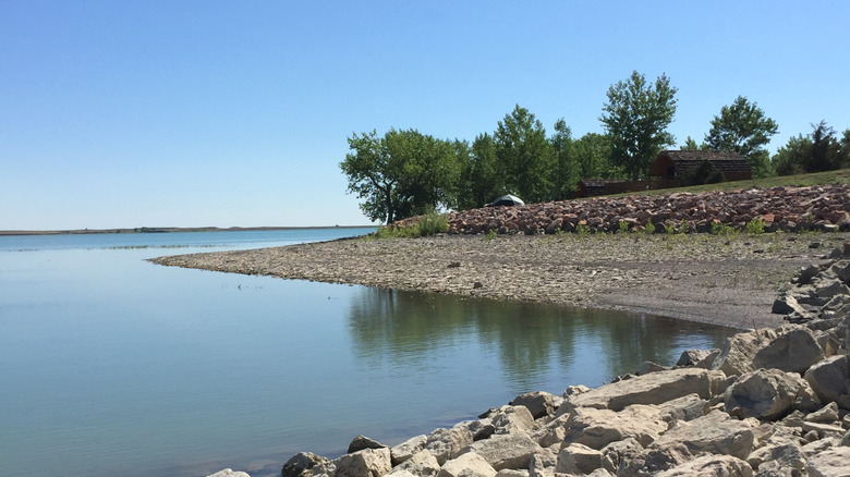 Rocky shoreline with trees on the Angostura Reservoir in Angostura Recreation Area, South Dakota.