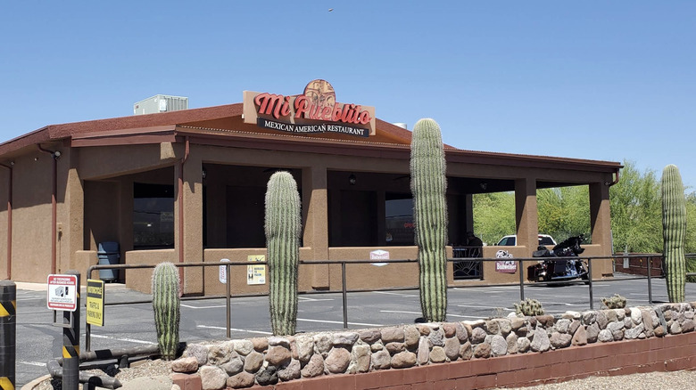 The exterior of Mi Pueblito, a Mexican-American restaurant in Mammoth, Arizona, behind cacti