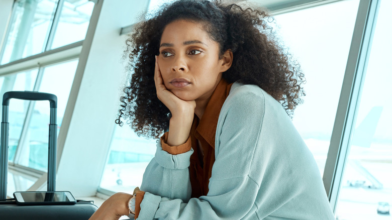 An anxious woman waits for her flight in the airport