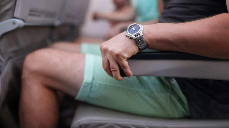 A passenger grips their airplane seat